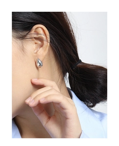 Close-up of a model wearing minimalist silver water drop stud earrings in S925 silver