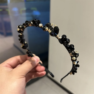 Detailed close-up of handmade luxury crystal headband with black gemstones and gold floral accents