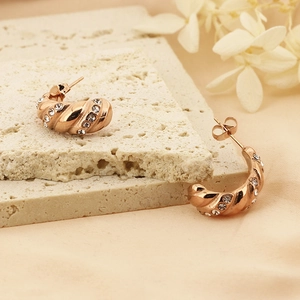 Orecchini a croissant in oro rosa 18k con texture ondulata e zirconi su base in pietra