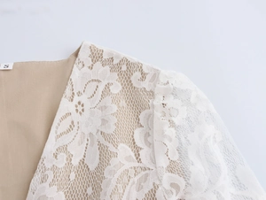 Close-up of elegant white floral lace texture and size S label on beige lining top