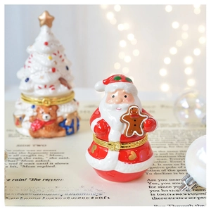 Detail of Christmas ceramic jewelry box set with Santa and Christmas tree on vintage book