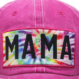 Macro detail of MAMA embroidery on a rainbow tie-dye patch with pink washed cotton fabric