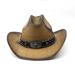 Détail d'un chapeau de cowboy en paille avec bandeau en cuir et emblème tête de taureau