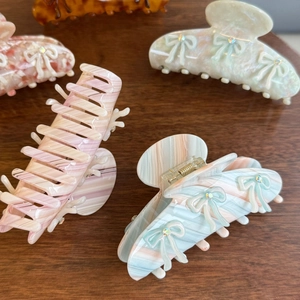 Detailed display of acetic acid bow hair claws in multiple colors with crystal accents
