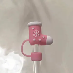 Detailed view of pink Christmas boot silicone straw cover with snowflake relief on glass straw