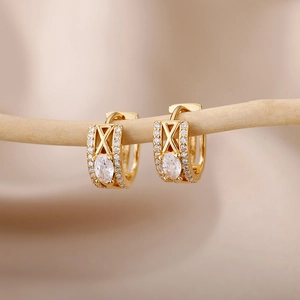 Detailed view of gold C-shaped hoop earrings with zircon pavé and oval center stone