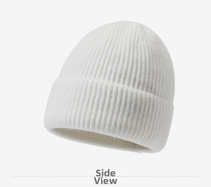 Close-up of white rib-knit beanie showing thick vertical texture and folded cuff detail