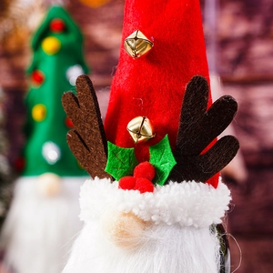 Close-up of a festive Christmas gnome wine bottle cover with reindeer antlers and bells