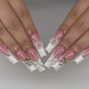 Detail of pink and white French press-on nails with 3D bows and cherry rhinestones