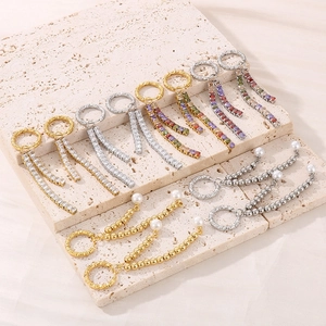 Detailed view of long rhinestone tassel earrings in gold and silver with colorful zircons