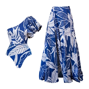 Detail view of one-shoulder ruffle swimsuit with matching tropical print high waist skirt