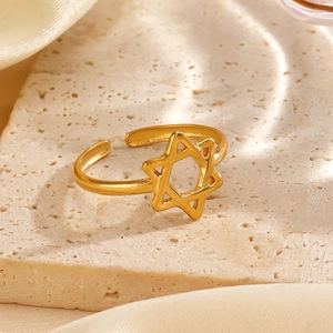 Minimalist gold star cutout open ring for women on an elegant marble and silk base