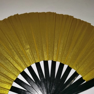Close-up of a 33cm Kung Fu fan with golden laser surface and black bamboo ribs