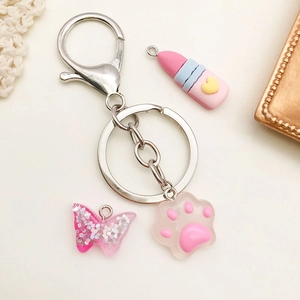 Pink lipstick and paw resin charm keychain with silver metal ring and butterfly detail