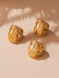 Detailed view of three chunky 18k gold plated stainless steel rings with hollow dot accents