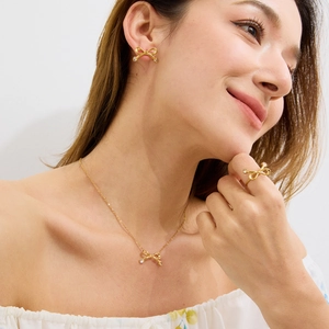 Parure de bijoux dorée avec nœuds et zircons sur mannequin pour la Saint-Valentin