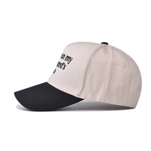 Close-up of two-tone cotton baseball cap featuring side text embroidery on a white crown