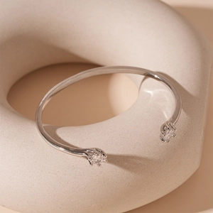 Detail of silver adjustable cuff bracelet featuring two round cubic zirconia in claw settings