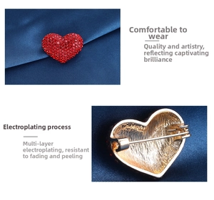 Detail view of red crystal heart brooch showing multi-layer plating and safety pin