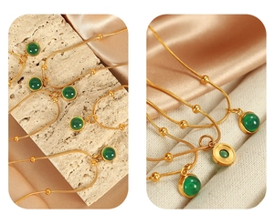 Detailed macro view of vintage green gemstone pendant on gold snake chain necklace