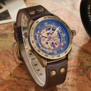 Detail of bronze skeleton watch with tachymeter bezel and riveted leather strap