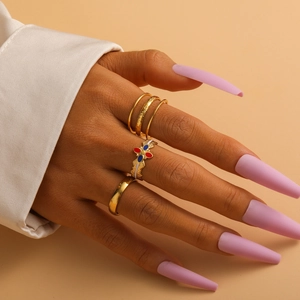 Close-up of elegant gold plated ring set with colorful enamel detail on a model hand