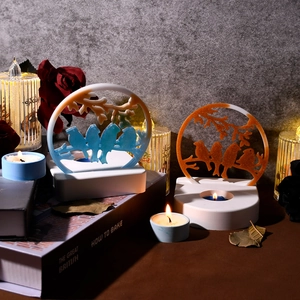 Detail view of bird silhouette resin candle holders on vintage book stacks