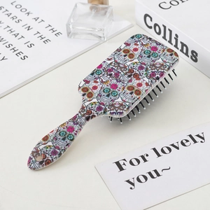 Sugar skull hair brush on a styled vanity table with books and perfume bottles