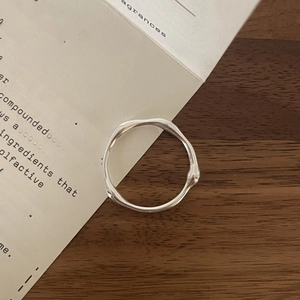 Makroaufnahme von S925 Silberring mit unregelmäßigen Wellen auf Holzoberfläche