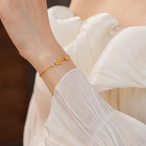 Détail d'un bracelet rose plaqué or 18 carats avec zircon sur tissu blanc plissé