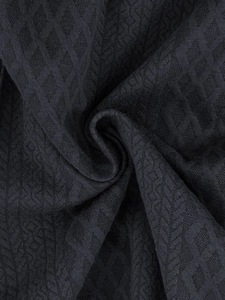 Detailed macro view of dark grey geometric jacquard fabric with textured fiber pattern