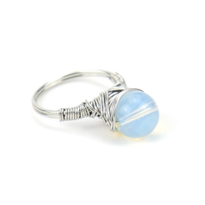Detail of silver wire wrapped ring with a blue translucent crystal round bead