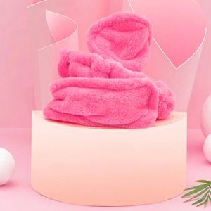 Detailed close-up of the soft pink plush velvet hair roller on a product display stand