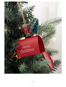 Detail of a red metal Christmas mailbox ornament with a reindeer figurine and a mini pine tree