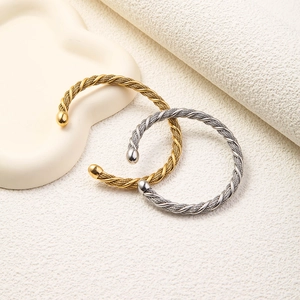 Detail of gold and silver twisted mesh wire open bracelets with spherical end caps