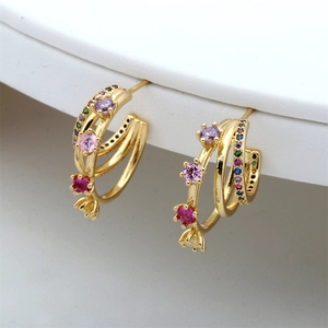 Detail of gold C-shaped earrings with colorful multi-layer stones and pavé crystals