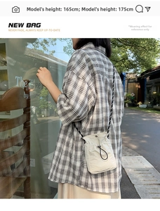 Outdoor street style view of an off-white drawstring water bottle crossbody bag