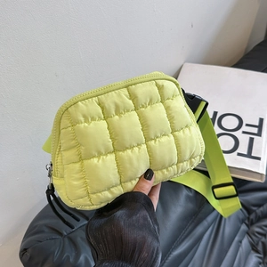 Detail view of lime green quilted crossbody bag with plaid stitching and wide strap