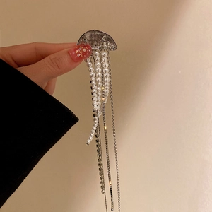 Close-up of silver jellyfish brooch with white pearls and sparkling rhinestone tassels