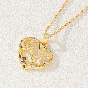 Macro shot of gold heart pendant with MOM lettering and zircon accents for women
