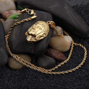 Detailed view of a gold Buddha pendant with a rope chain on dark textured stones