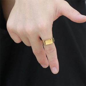 Close-up of a polished gold signet ring with a sleek rectangular flat top on a model finger