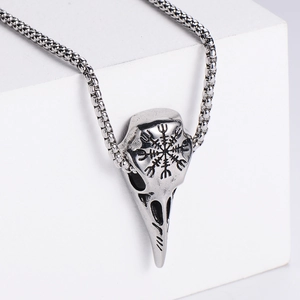 Macro shot of Viking raven skull pendant with Vegvisir compass engraving in steel