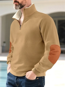 Detail of camel quarter-zip pullover showing orange elbow patches and rib-knit texture