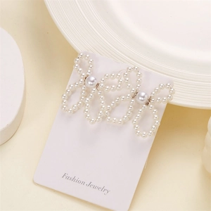 Detailed view of handmade bow-shaped earrings crafted with woven imitation pearls