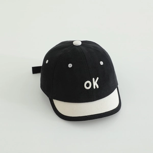 Detail der ok Stickerei auf der schwarzen Canvas Baseballkappe mit weißem Schirm