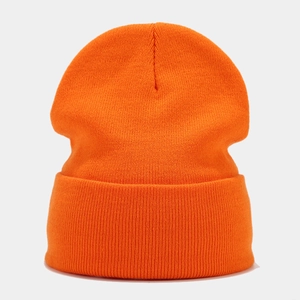 Close-up of bright orange knitted beanie featuring tight textured patterns and rolled cuff