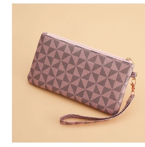 Detail of pink clutch bag featuring geometric triangle patterns and gold zipper hardware