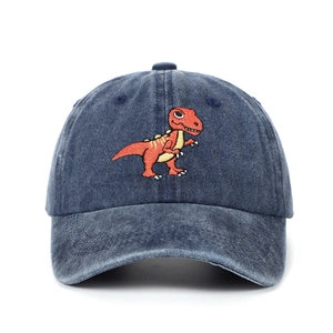 Close-up of detailed T-Rex dinosaur embroidery on washed navy blue kids baseball cap