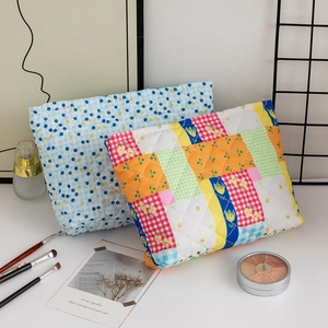 Detail view of quilted floral and checkered makeup bags with soft diamond stitching